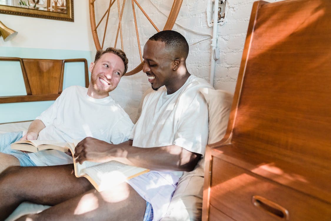 Couple sitting with books in their hands smilling at each other