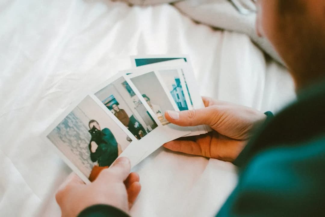 A man is holding a couple of photos in his hands