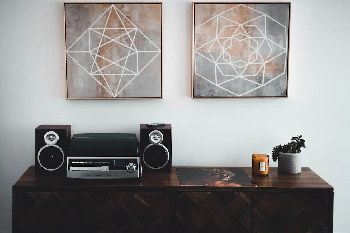 Home decor with two pictures on a wall and cabinet with radio on top